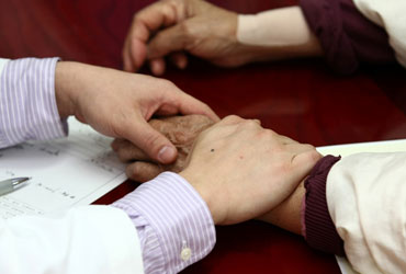 평촌자생한의원 자생치료의 특징-환자 손을 잡아 건강상태를 체크 하고 있는 의사의 모습